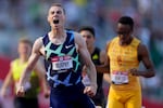 Several runners are visible. The person in the front has his mouth open as though he is shouting in exhilaration.