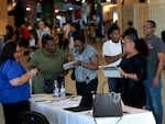 Job seekers fill out forms at the Jamaican Restaurant booth setup at the Mega South Florida Job Fair held in the FLA Live arena in Sunrise, Fl., on Feb. 23, 2023. Leisure and hospitality are among the sectors that are in need of workers.