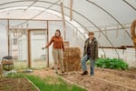 Audrey Barbour, left, and Kelly Sauskojus, right, check out the greenhouse at Battlefield Farm in Knoxville, Tenn., a community garden and alternative congregation started by Pastor Chris Battle.