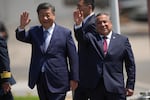 Chinese President Xi Jinping, left, and Peru's Prime Minister Gustavo Adrianzen, wave on the airport tarmac after Xi's arrival to attend the Asia-Pacific Economic Cooperation (APEC) summit, in Lima, Peru, Thursday, Nov. 14, 2024.