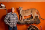 Carter Niemeyer poses with some of the animals he has preserved using taxidermy.