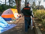 Last month, the city of Portland cleared 70-100 makeshift homes of people living near Laurelhurst Park last month. Tyler Hardy, one of those who have returned, stands outside his shelter, Dec. 7, 2020.