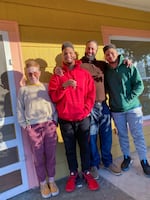 Annie Moss, left, on the porch of the Albina neighborhood home Moss sold to Randal Wyatt, (second from right) and his family in December 2020. Moss purchased the home in 2013, and sold it in 2020 to Wyatt, for what was left on the mortgage — well below the estimated fair market value of the home. 