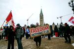 Don Stephens, 65, a retired graphic designer, holds a sign on Parliament Hill to support trucks lined up in protest of COVID-19 vaccine mandates and restrictions in Ottawa, Ontario, on Saturday, Feb. 12, 2022. Stephens said he’s come into Ottawa twice to show support for protesters there. He views them as representatives of a “silent majority that had been longing to have their voice heard.”