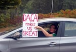 FILE - An unidentified woman holds a sign out her window as she drives through rush hour traffic in Portland, Ore., Sept. 5, 2017. 