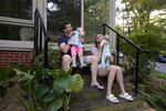 Micaeli and Gerhard du Plessis sit on the steps with their kids.