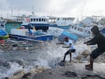 Fishermen pull a boat damaged by Hurricane Beryl back to the dock at the Bridgetown Fisheries in Barbados on Monday. 