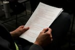 An audience member holds a printed copy of a proposed new article at the Woodburn Education Association and Woodburn School District bargaining session on Oct. 16, 2025, at the district office. The proposed article would add and solidify protections for staff if targeted by U.S. immigration enforcement officers.