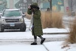 Pedestrian crosses the street during a snowy day in Vernon Hills, Ill., Wednesday.