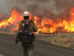 A firefighter stands in front of the Nena Springs Fire on the Warm Springs Reservation in Central Oregon.