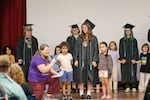 Metropolitan Learning Center senior Bella Kjellander stands with her kindergarten “buddies” at graduation on Friday, June 5, in Portland, Ore. The school’s K-12 system encourages interactions across grades.