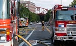 A firefighter walks between multiple fire engines as multiple fire crews and other emergency personnel monitor and battle a fire in Northwest Portland, Ore., on Aug. 2, 2026.
