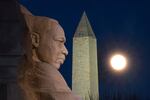 The rising full moon passes behind the Martin Luther King Memorial and the Washington Monument, Tuesday evening, Dec. 29, 2020, in Washington.