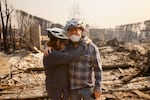 Claudio and Kathleen Boltiansky embrace in their fire-ravaged neighborhood after the Palisades Fire swept through in the Pacific Palisades neighborhood of Los Angeles, Wednesday, Jan. 8, 2025.