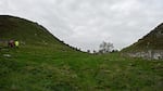 Two men are now convicted of charges related to cutting down a historic tree in England. A combination of pictures shows, top, the Sycamore Gap tree along Hadrian's Wall near Hexham, northern England on June 4, 2023, and bottom, the felled Sycamore Gap tree, on Sept. 28, 2023.