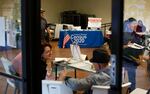 Volunteers at a February 2020 community event in Guadalupe, Ariz., gather near a table with information on how to apply for census jobs.