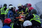 Rescue workers carry an injured woman on a stretcher from a house heavily damaged after a Russian strike on a residential neighborhood in Kyiv, Ukraine, on Thursday, May 14, 2026.