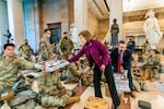 Rep. Vicky Hartzler, R-Mo., and Rep. Michael Waltz, R-Fla., hand pizzas to members of the National Guard gathered at the Capitol Visitor Center, Wednesday, Jan. 13, 2021, in Washington. as the House of Representatives continues with its fast-moving House vote to impeach President Donald Trump, a week after a mob of Trump supporters stormed the U.S. Capitol.