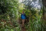 David Sischo walks through a rainy forest. Sischo is working to save some of the rarest endangered species on the planet, kāhuli – Hawaii’s native tree snails. The snails play a crucial role in the ecosystem, having evolved over millions of years on the isolated islands. 