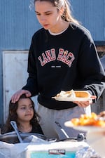 Nohea‘ililani Waiwai‘ole and her daughter Kaualanipili load their plates at the potluck hosted at the māla on Unity Farms in Portland, Ore., on Saturday, Sept. 27, 2026.