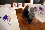 Aliza Bidinger is accompanied by her son Jayce, age 6, as she votes at the 146-year-old Buck Creek school on Election Day, Tuesday, Nov. 5, 2024, in rural Perry, Kan. (AP Photo/Charlie Riedel)