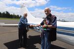 Veterans Simon Rowland and Guy McMackin shake hands at Pearson Field after a flight together on a P-Model Cessna plane.
