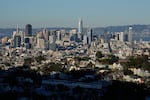 Homes are illuminated by sunlight as the San Francisco skyline is seen in the background, Friday, Oct. 17, 2025, in San Francisco.