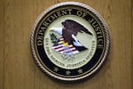 FILE - A Department of Justice logo is shown on a podium during a news conference, Sept. 30, 2010, in Philadelphia.