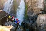 Confederated Tribes of the Grand Ronde tribal members Sara Thompson, left, and Matt Zimbrick, center, along with the tribe’s fish and wildlife program director Kelly Dirksen, navigate the rocks at Willamette Falls, a waterfall just south of Portland that has long been an important fishing site for the region’s tribes. In recent years, salmon counts at Willamette Falls have reached historic lows.