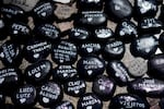 Black round rocks are painted with names and small white hearts.