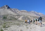 Researchers and students hike across the pumice plain north of Mount St. Helens toward the crater on Friday, July 23, 2004, in Windy Ridge, Wash. Scientists from around the world have come to the volcano to study its plants and geology since its May 18, 1980 eruption.