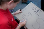 A student draws a sign supporting Sellwood Middle School.
