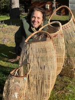 Sophie Weinstein's mother, Lisa Hillman, is a master basket weaver. She poses with some of the variously sized hazel baskets she has created.