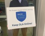 A parent holds a sign for the Online Learning Academy at a Portland Public Schools board meeting on March 7, 2023. In January, district officials announced the closure of the program at the end of this school year.