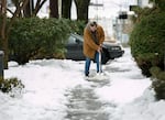 A man shovels the sidewalk on Northeast 21st Avenue near Wasco Street in Portland, on Tuesday, Feb. 16, 2021. The metro area continues to dig out following the weekend's snow and ice storms.