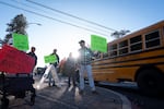 FILE — A school bus drives past as people protest outside the Bend-La Pine Schools Education Center on Oct. 23, 2026, in Bend, Ore.