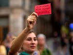 A demonstrator holds a red card reading in Spanish "it is over" during a Sept. 4 protest against Luis Rubiales in Barcelona.
