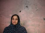 A Palestinian woman stands in her home after an Israeli strike in Rafah, Gaza Strip, Sunday, Dec. 24, 2023.