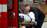 A paramedic from the Redmond Fire District loads a woman who fell in her garage into an ambulance. A shortage of paramedics in Redmond could lead to increased response times to emergencies like this, officials said.