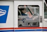 a postal worker behind a vehicle window