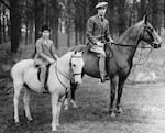 Circa 1930s: King George VI rides horses with his daughter Princess Elizabeth.