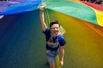 Sophia Lewis, 13, of Maryland Heights, Mo., helps hoist a giant rainbow flag down Market Street on June 25, 2023, during the St. Louis PrideFest Parade in downtown St. Louis.