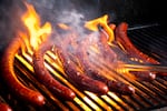 Blake Foraker grills gene-edited German-style sausages at Washington State University.