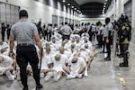 In this photo provided by El Salvador's presidential press office, a prison guard transfers deportees from the U.S., alleged to be Venezuelan gang members, to the Terrorism Confinement Center in Tecoluca, El Salvador, March 16, 2025.