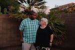 DeForrest and Bobbie look at each other as they stand in front of palm trees outside their home in Arizona.