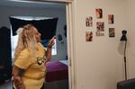 Valaria Zayas points out photos of family in their apartment in Los Angeles.