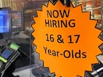 Signage advertising now hiring for 16- and 17-year-old employees is displayed on a cash register inside a discount department retail store in Las Vegas.