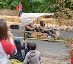 Barbara Moynier, left, records the Bridge City Bandits soapbox derby team as they careen down the track.