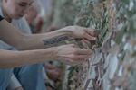 Kateryna Kyshkan, 36, weaving strips of cloth into a giant net to make camouflage netting.