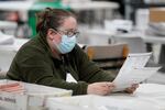 An official works on ballots at the Gwinnett County Voter Registration and Elections Headquarters, Friday, Nov. 6, 2020, in Lawrenceville, near Atlanta.